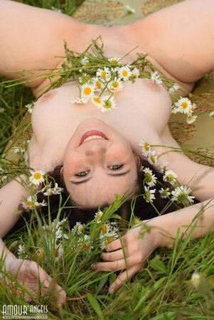 Girl made flower crown deserving herself a princess and exposing charms in a field
