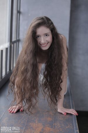 Long-haired brunette Flo climbs windowsill to relax there like a nude nymph