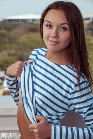 Woman in striped top and jeans takes them off exposing her tan lines