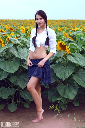 Sexpot finds a spacious sunflower field and strips naked under the sun