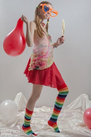Fancy girl with red balloons and in striped socks bares her small fun parts