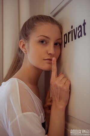 Skinny slut reveals private parts in her bed in front of the window
