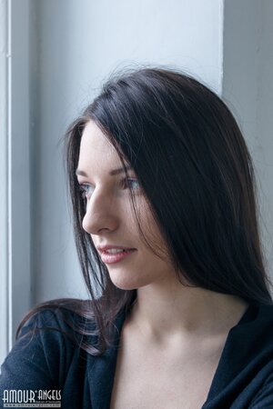 Teen brunette Kiara Lord sits on a windowsill and exposes her tiny erogenous zones
