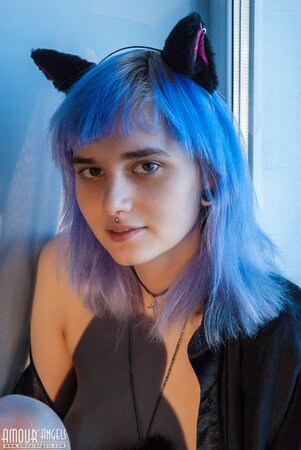 Shy alt girl while sitting near window seductively demonstrates tits and pussy