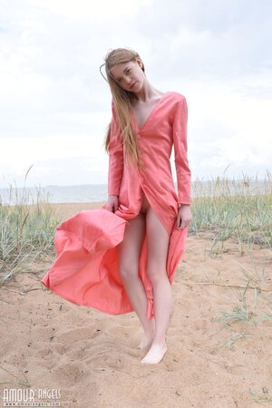 Skinny babe walks naked around spacious field dressed only in a sexy dress