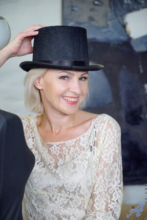 Beautiful female with a black hat takes her private parts to light