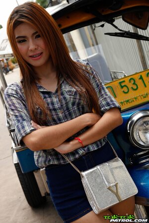 Exotic teen with red hair demonstrates her braces while posing near rickshaw