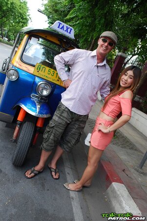 Joyful Thai minx poses near white fellow and his impressive auto rickshaw