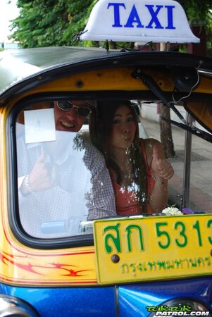 Joyful Thai minx poses near white fellow and his impressive auto rickshaw