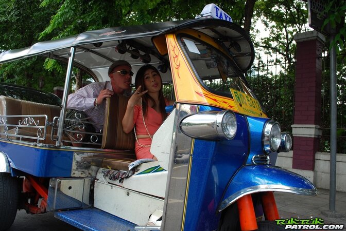 Joyful Thai minx poses near white fellow and his impressive auto rickshaw
