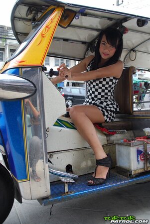 Inviting Thai model in a checkered dress gets into the Tuk Tuk Taxi