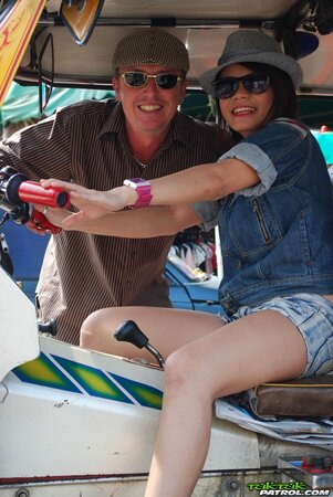 Joyful exotic teen agrees to pose with mature guy near auto rickshaw