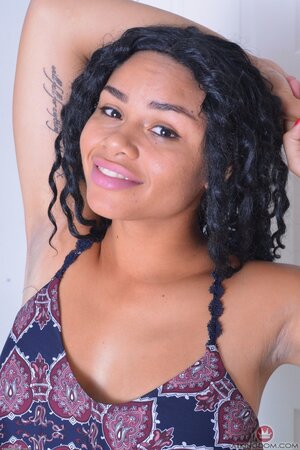 Black slut undresses looking into the camera and exposing her pussy