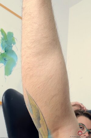 Tattooed female with glasses takes her shorts down airing pierced woolly peach