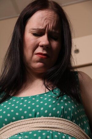 Pervert catches woman in green polka dot dress and ties her to chair