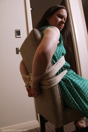 Pervert catches woman in green polka dot dress and ties her to chair