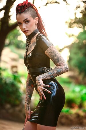 Goth girl in a vinyl dress poses on camera exposing her muff for cash