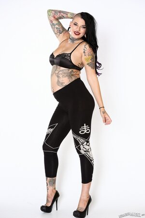 Appealing pornstar in black bra and pants prefers to pose with naked tattooed body