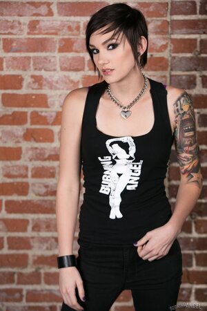 Girl with short hair and tattoos flashes small tits with nipple piercing