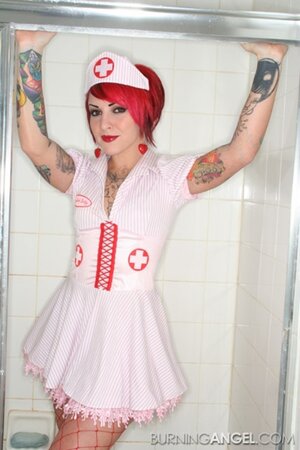 Nurse with red hair and meaningful tattoos over her body touches her cunt