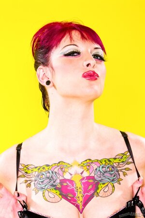 Sweetie with middle-sized boobs starts striptease on a yellow background