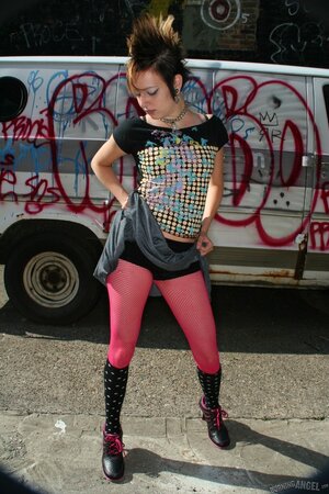 Sexy punk woman with a mohawk pulls her pink pantyhose down to show the vagina