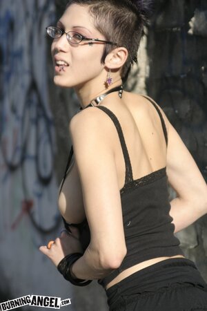 Sexy goth girl with glasses and mohawk shamelessly exposes her pussy outdoors