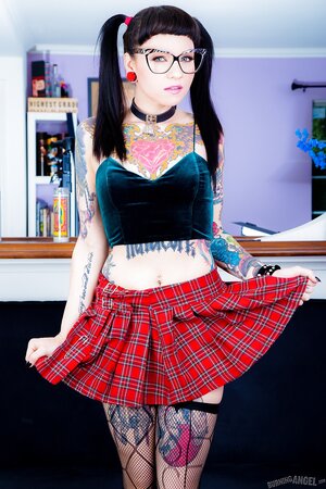 Pigtailed bookworm with ear stretching plugs and tattoos flashes private parts