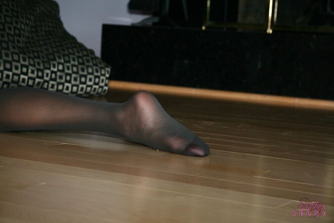 In the evening sexy MILF tries on black pantyhose without wearing panties