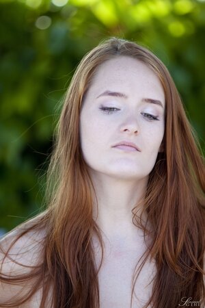 Comely redhead Denisa Heaven prefers to relax completely naked under the sun