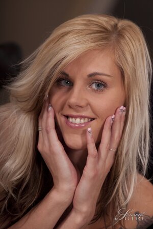 Petite blonde with sexy tattoos gets nude while posing with her tiny tits shown