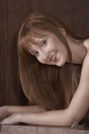 Enticing Euro redhead smiles while posing completely nude on the floor