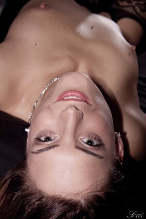 Slender brunette provocatively smiles while demonstrating body on the camera