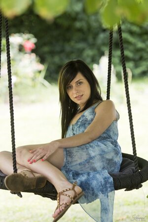 Seductive tender brunette undressing to show her awesome pussy on a swing