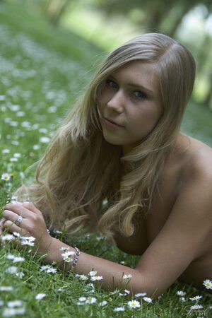 Young blonde feels unity with nature while walking naked in the field
