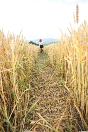 During walk through field of wheat young redhead takes a break to rub pussy