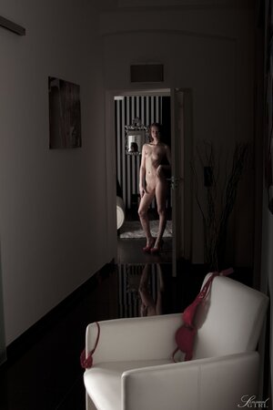 Pale-skinned naked girl with red hair and cute face wears nothing but heels