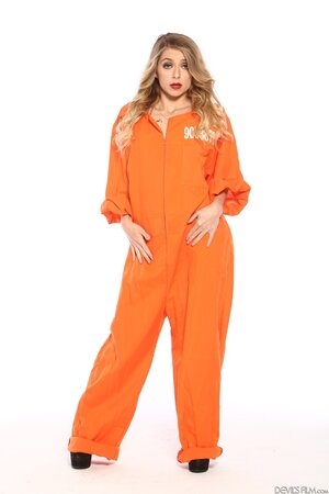 Female inmate in orange uniform flashes pierced nipple to seduce prison guard