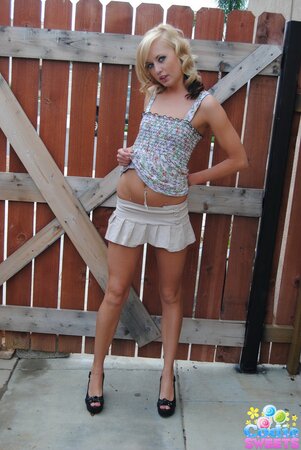 Naughty teen blonde teases with her tiny tits and shaved pussy outdoors