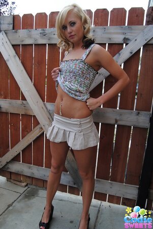 Naughty teen blonde teases with her tiny tits and shaved pussy outdoors