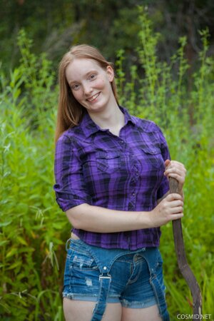 Red-haired country girl strips to flaunt her big breasts in the woods