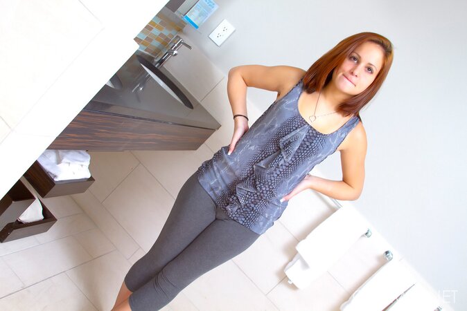 Red-haired cutie takes off yoga pants and poses with her tiny tits showing