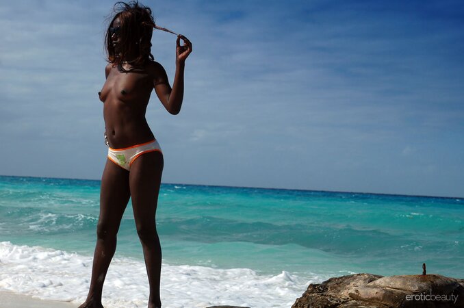 Small-assed black slut with tiny titties gets naked on the rocky shore
