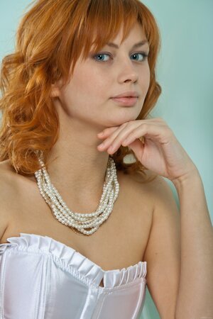 Dazzling red-haired nympho pulls off white corset and shakes her perky tits
