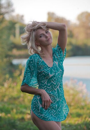Excited slim blonde poses showing her small boobs and trimmed cunt on the meadow