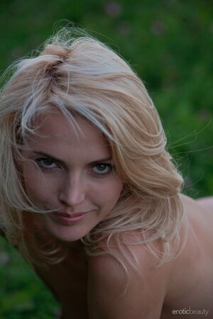 Excited slim blonde poses showing her small boobs and trimmed cunt on the meadow