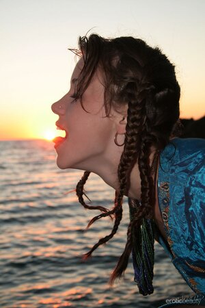 Ukrainian teen in exotic blue coat shows off skinny body by the ocean