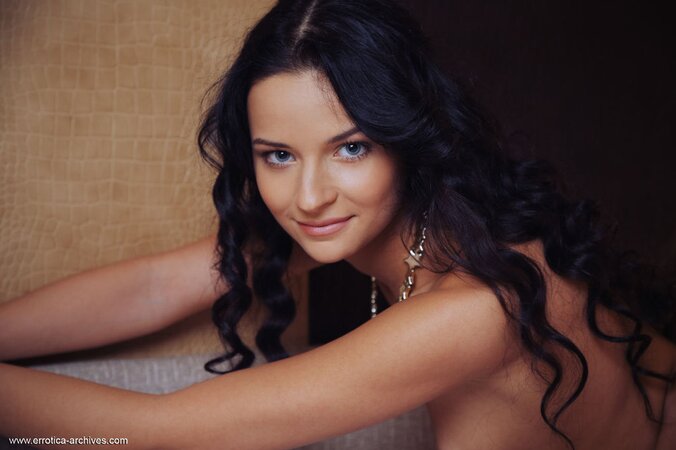 Slender brunette spreads legs wide while relaxing naked in the bedroom