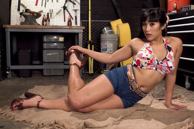Slender Asian babe in tight jean shorts gets on the floor to tease with her feet