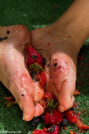 Two horny lezzies squash berries with feet and lick toes before riding dildo
